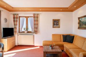 a living room with a couch and a tv at Alpenblick Tilly - Fewo Lautersee 3 in Krün