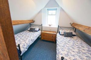 zwei Einzelbetten in einem Zimmer mit Fenster in der Unterkunft Shellsborough Penthouse in Woolacombe