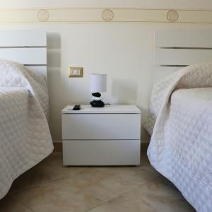 a bedroom with two beds and a lamp on a night stand at MariSte Apartment in Parghelia