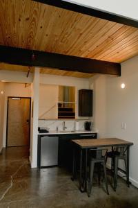 a kitchen with a wooden ceiling and a table at Loom Room Retreat in Dalton +4 photos