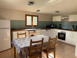 a kitchen with a table and a table and chairs at gîte la petite ferme Peyre in Créon-dʼArmagnac
