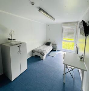 Un dormitorio con una cama, un escritorio y una mesa. en Hostel Września, en Września