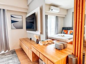 un soggiorno con letto e tavolo in legno di Luxe City Studio Hideaway a Città di Iloilo