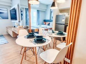 una cucina e un soggiorno con due tavoli e sedie di Luxe City Studio Hideaway a Città di Iloilo