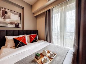 una camera d'albergo con letto e vassoio con set per la preparazione del tè di Luxe City Studio Hideaway a Città di Iloilo