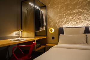 a hotel room with a bed and a desk and a chair at Letoh Letoh Bilbao in Bilbao