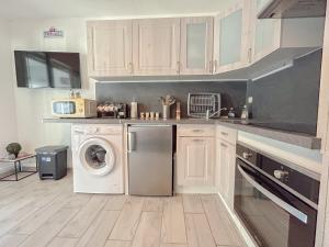 a kitchen with a washing machine and a washer at 2 pièces apartement à Fréjus avec parking in Fréjus