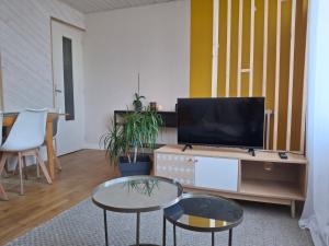 a living room with two tables and a television at Maison au calme idéale pour découvrir Sud Finistère in Quimper