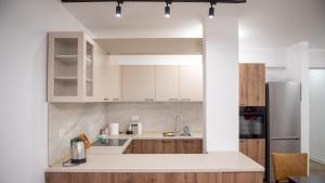 a kitchen with white cabinets and a refrigerator at Apartments Rooftop Prilep in Prilep