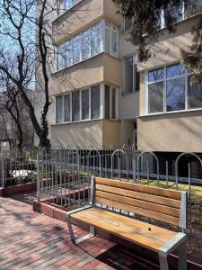 a wooden bench sitting in front of a building at Dulce Luna in Bucharest