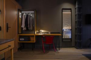 a dressing room with a desk and a red chair at Letoh Letoh Bilbao in Bilbao