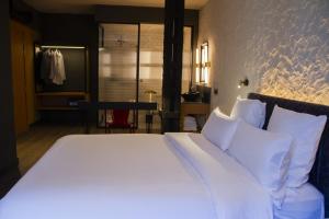 a bed with white sheets and pillows in a room at Letoh Letoh Bilbao in Bilbao