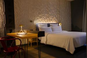 a hotel room with a bed and a table at Letoh Letoh Bilbao in Bilbao