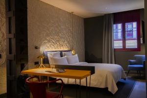 a hotel room with a bed and a table and a window at Letoh Letoh Bilbao in Bilbao