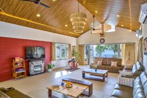 a living room with a red brick wall at SaffronStays Eagle's Span in Malavli