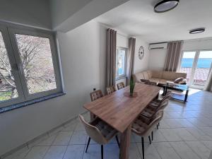 a dining room with a wooden table and chairs at Apartment Tribanj Florida in Viniština