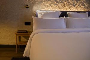 a large white bed with white pillows and a table at Letoh Letoh Bilbao in Bilbao