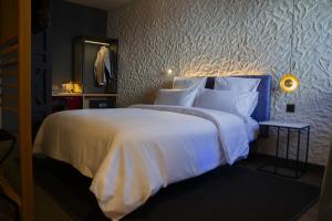a bedroom with a large bed with white sheets and pillows at Letoh Letoh Bilbao in Bilbao