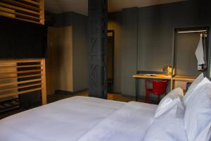 a bedroom with a bed and a desk with a red chair at Letoh Letoh Bilbao in Bilbao