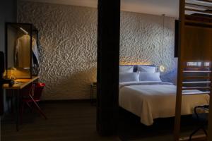 a hotel room with a bed and a desk with a television at Letoh Letoh Bilbao in Bilbao