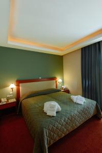 Una habitación de hotel con una cama con dos toallas. en Athens Mirabello en Athens