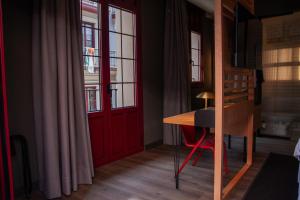 a room with a red door and a wooden desk at Letoh Letoh Bilbao in Bilbao