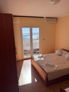 a bedroom with a bed and a large window at Apartment Tribanj Florida in Viniština