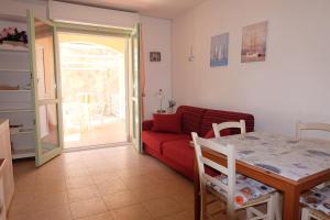 サン·ヴィンチェンツォにあるOnda etrusca con giardino tranquillo riservato Pet Friendlyの赤いソファとテーブルのあるリビングルーム