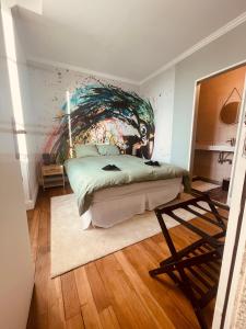 a bedroom with a bed with a painting on the wall at La Galerie, suite pour 2 personnes avec chambre supplémentaire possible in Saint-Fargeau