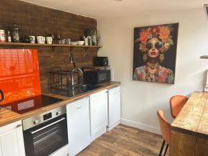 a kitchen with a black woman painting on the wall at Aiskew Villa Annex in Bedale