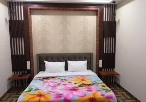 a bedroom with a bed with flowers on it at Hotel New Kesar Palace in Agolai +18 photos