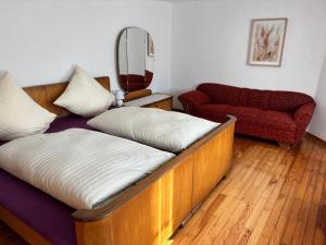 Habitación con cama, sofá y espejo. en Ferienhaus Schouhfranzen, en Gornhausen 13 fotos más
