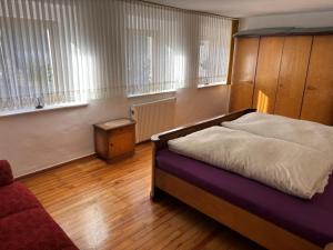 a bedroom with a bed and a couch and windows at Ferienhaus Schouhfranzen in Gornhausen