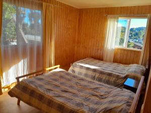 two beds in a room with a window at Casa en centro Puerto Montt in Puerto Montt