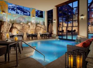 a large pool in a resort with tables and chairs at Snake River Lodge & Spa in Teton Village