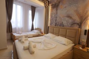 Una habitación de hotel con dos camas con toallas. en Golden Sleep Hostel, en Shkodër