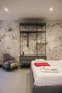 a bedroom with a bed and a mirror and a chair at Moss & Stone - 3 min walk to piazza Vittoria in Brescia