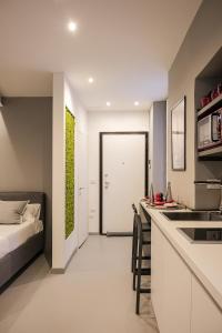 a bedroom with a bed and a kitchen with a counter at Moss & Stone - 3 min walk to piazza Vittoria in Brescia