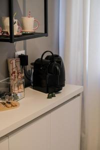 a kitchen counter with a toaster on top of a cupboard at Moss & Stone - 3 min walk to piazza Vittoria in Brescia