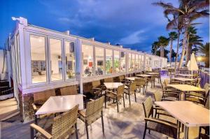 una fila de mesas y sillas en un restaurante en Las Brisas Villa 106, en Playa Blanca