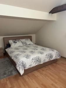a bedroom with a bed with a white and black comforter at Noclegi Opole-Chmielowice Apartament C in Opole