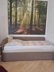 a bed in a room with a picture of a forest at Exclusive Apartments in Bietigheim-Bissingen