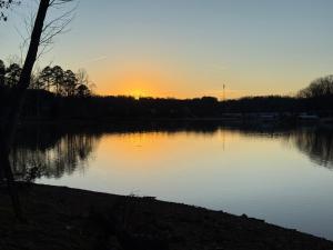 a sunset over a lake with the sun setting at High Rock Haven in Lexington