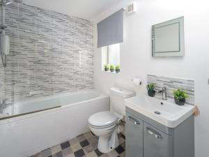 a bathroom with a toilet and a tub and a sink at Sea Thrift Nook Amble in Amble