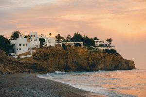 a group of houses on a cliff next to the ocean at Villa Mistral Montiboli by Buccara in Villajoyosa