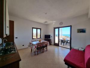 una cucina e un soggiorno con tavolo e sedie di Villa Eugenia a Tropea