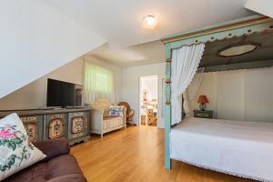 a bedroom with a canopy bed and a couch at Strandtraum Lobbe Fewo 20 bis 4 Personen, auf Anfrage mit Strandkorb in Lobbe