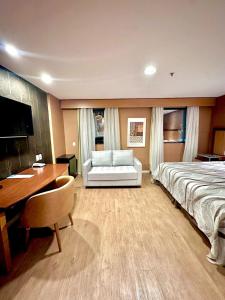a hotel room with a bed and a desk and a desk at Flat 805 - Avenida Ibirapuera, Moema - São Paulo in Sao Paulo