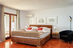 a bedroom with a large bed and a chair at Villa Poniente Montiboli by Buccara in Villajoyosa
