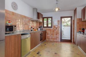 a large kitchen with wooden cabinets and appliances at Villa Poniente Montiboli by Buccara in Villajoyosa +12 photos